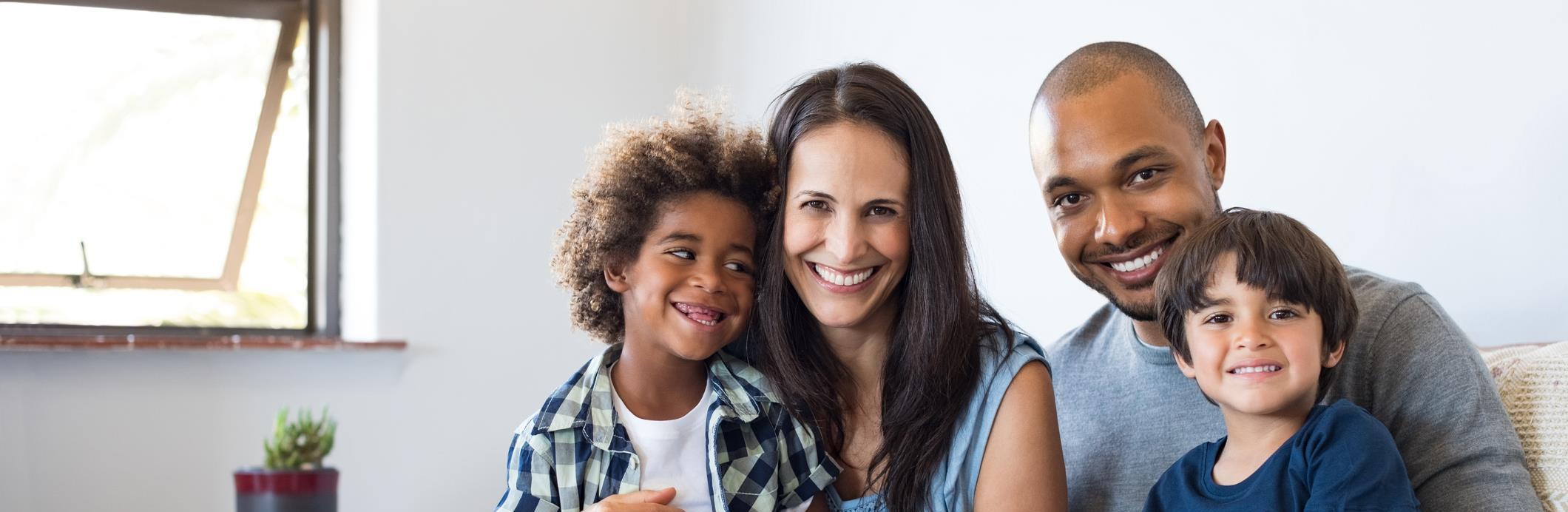 Multi-racial family holding drawing of happy family