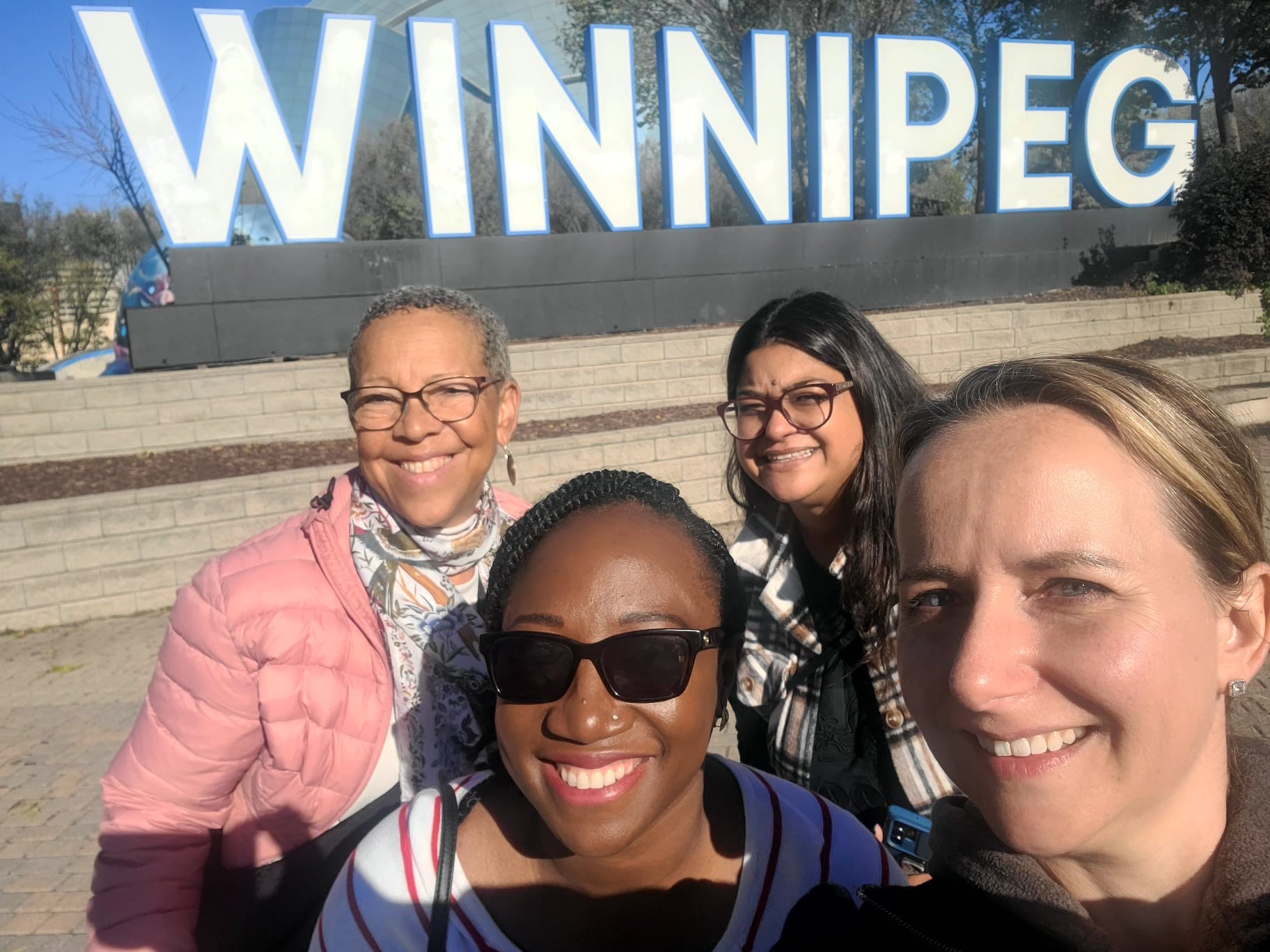 Team in front of Winnipeg sign